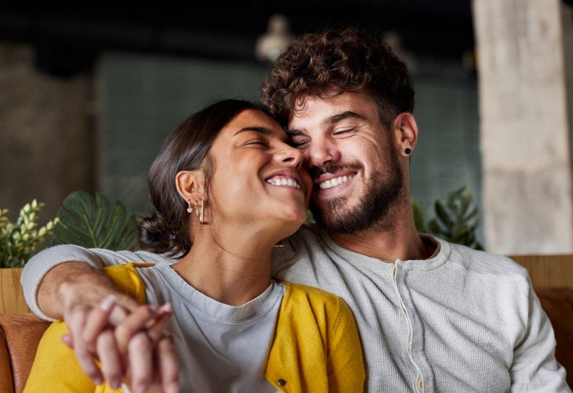 A couple laughing together, cheek to cheek
